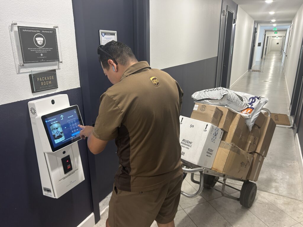 A UPS courier using a Smart Package Room kiosk to bulk deliver packages securely into a multifamily package room, streamlining last mile delivery and reducing dwell time.